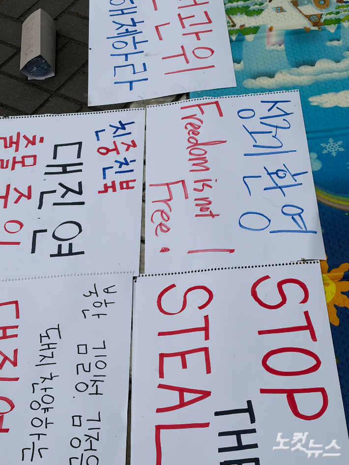 8일 오전 집회 현장 바닥에 놓인 팻말들의 모습. 박인 기자 