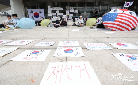 6·3 지방선거 투표용지 부족 사태를 규탄하고 재선거를 요구하는 '잠실 개표소 봉쇄 시위'가 나흘째 이어지고 있는 8일 서울 송파구 올림픽공원 핸드볼경기장 출입구 앞에서 시위 참가자들이 구호를 외치고 있다.