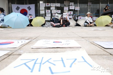 6·3 지방선거 투표용지 부족 사태를 규탄하고 재선거를 요구하는 '잠실 개표소 봉쇄 시위'가 나흘째 이어지고 있는 8일 서울 송파구 올림픽공원 핸드볼경기장 출입구 앞에서 시위 참가자들이 구호를 외치고 있다.