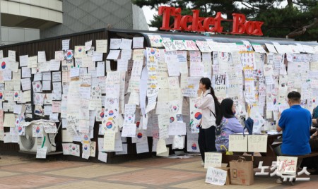 6·3 지방선거 투표용지 부족 사태를 규탄하고 재선거를 요구하는 '잠실 개표소 봉쇄 시위'가 나흘째 이어지고 있는 8일 서울 송파구 올림픽공원 핸드볼경기장 인근 티켓박스에 재선거를 요구하는 종이들이 붙어 있다.
