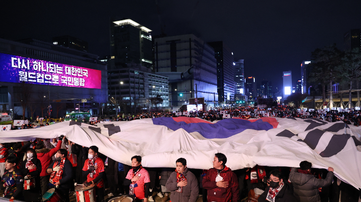 지난 2022년 12월 2일 밤 서울 종로구 광화문 광장에서 열린 2022 카타르 월드컵 H조 예선 한국과 포르투갈 경기 합동 응원에 나선 붉은악마와 시민들이 대형 태극기를 펼치며 응원을 펼치고 있다. 연합뉴스