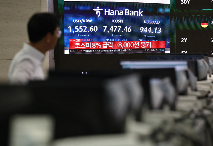 급락장에 코스피 서킷 브레이커가 발동된 8일 오전 서울 하나은행 본점 딜링룸에서 관계자가 관련 방송을 보고 있다. 연합뉴스