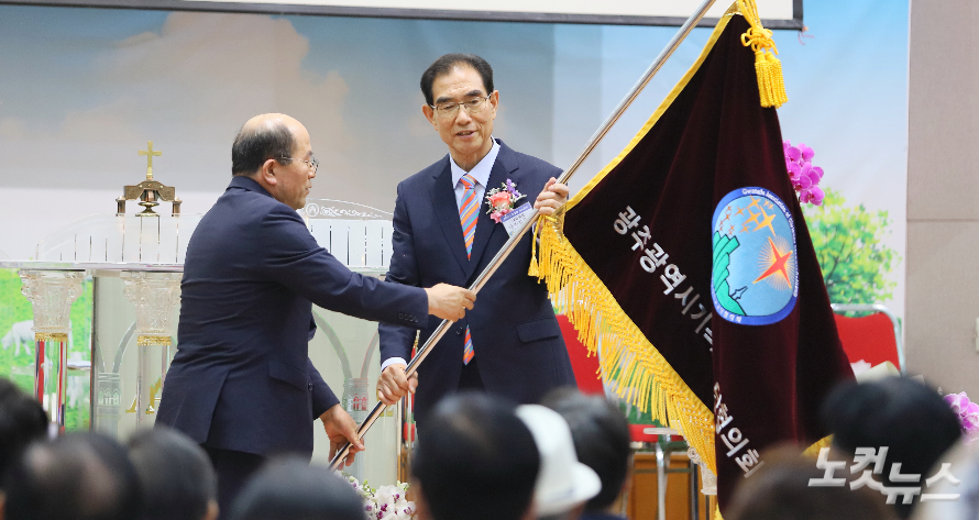 직전회장 정석윤 목사가 신임 대표회장 나종갑 목사에게 광교협 기를 전달하고 있다. 한세민 기자