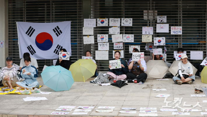 6·3 지방선거 투표용지 부족 사태를 규탄하고 재선거를 요구하는 '잠실 개표소 봉쇄 시위'가 나흘째 이어지고 있는 8일 서울 송파구 올림픽공원 핸드볼경기장 출입구 앞에서 시위 참가자들이 구호를 외치고 있다. 류영주 기자