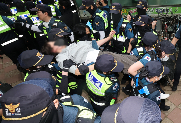 지난 5일 오전 서울 송파구 잠실7동 2투표소 앞에서 경찰이 투표함 이송을 위해 이를 막아선 시위대를 강제 해산 조치하고 있다. 연합뉴스