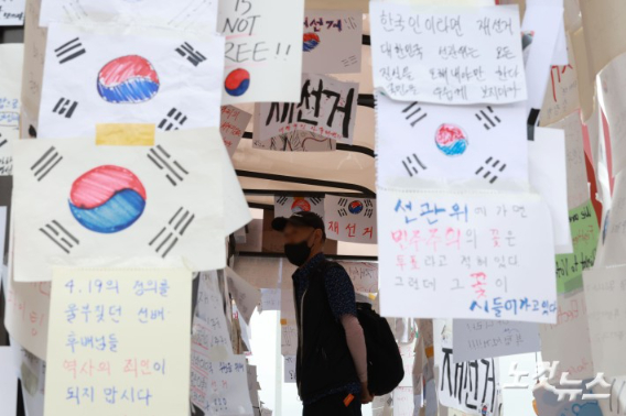  6·3 지방선거 투표용지 부족 사태를 규탄하고 재선거를 요구하는 '잠실 개표소 봉쇄 시위'가 나흘째 이어지고 있는 8일 서울 송파구 올림픽공원 핸드볼경기장 인근 티켓박스에 재선거를 요구하는 종이들이 붙어 있다. 류영주 기자