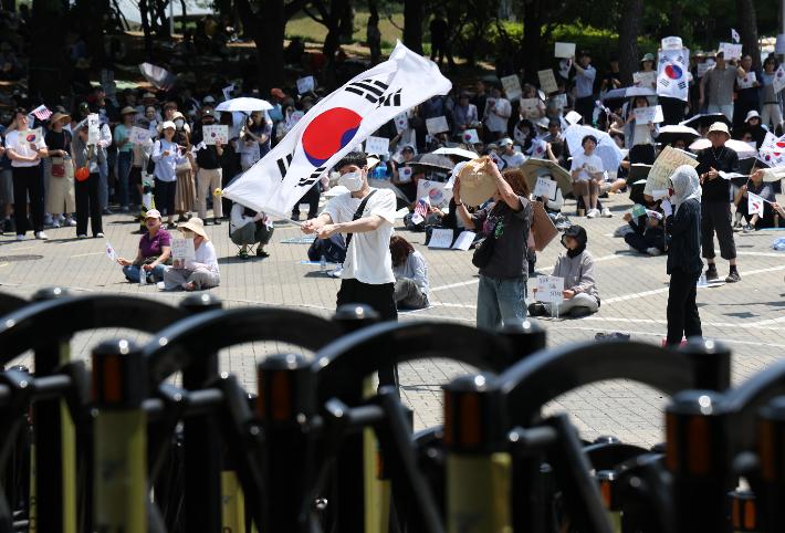 6·3 지방선거 투표용지 부족 사태를 규탄하며 재선거를 요구하는 '잠실 개표소 봉쇄 시위'가 계속되고 있는 9일 서울 송파구 올림픽공원 핸드볼경기장에서 시민들이 구호를 외치고 있다. 연합뉴스