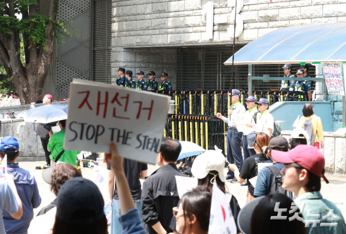 6·3 지방선거 투표용지 부족 사태를 규탄하고 재선거를 요구하는 '잠실 개표소 봉쇄 시위'가 나흘째 이어지고 있는 지난 8일 서울 송파구 올림픽공원 핸드볼경기장 출입구 앞에서 시위 참가자들이 구호를 외치고 있다. 류영주 기자