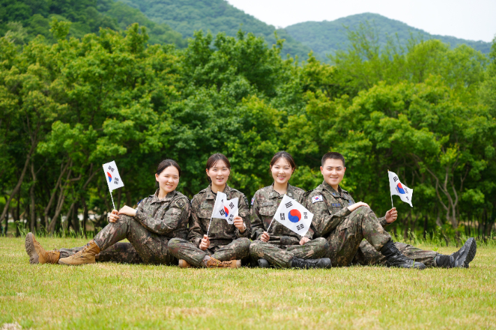 육·해·공군 부사관으로 복무 중인 김문정 중사, 김문소 중사, 김태희 중사, 김준원 하사(왼쪽부터) 4남매가 호국보훈의 달을 맞아 태극기를 들고 기념사진을 촬영하고 있다. 육군 제공