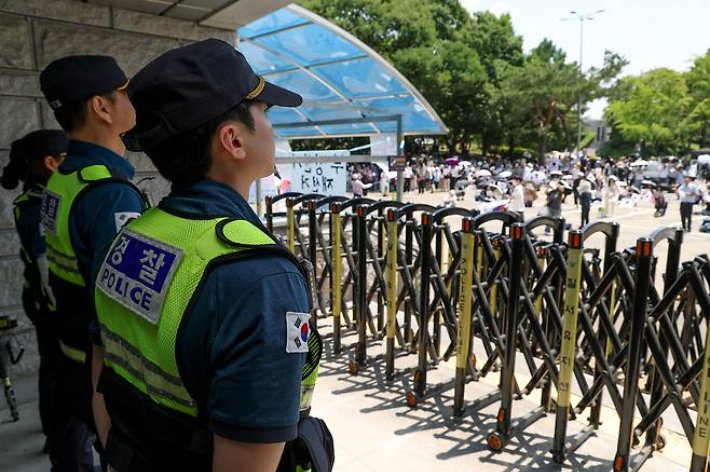 6·3 지방선거 투표용지 부족 사태를 규탄하는 '잠실 개표소 봉쇄 시위'가 계속되고 있는 가운데 지난 9일 서울 송파구 올림픽공원 핸드볼경기장 출입구 앞에 경찰관들이 서 있다. 연합뉴스