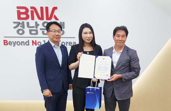 BNK경남은행 소답동지점 직원(사진 가운데)이 창원서부경찰서 형사지원팀 남인균 팀장(사진 오른쪽)으로부터 감사장을 받은 뒤 기념촬영을 하고 있다. BNK경남은행