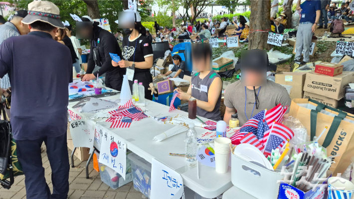 10일 오후 서울 송파구 잠실 개표소를 봉쇄하는 집회에서 자원봉사자들이 성조기를 무료로 나눠주고 있다. 김지은 기자
