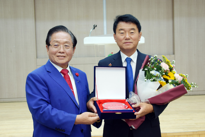 서천군성시화운동본부 본부장 정진모 목사(사진 왼쪽)가 서천군수 유승광 당선인(사진 오른쪽)에게 축하패와 꽃다발을 전달하고 있다. 사진: 서천군성시화운동본부