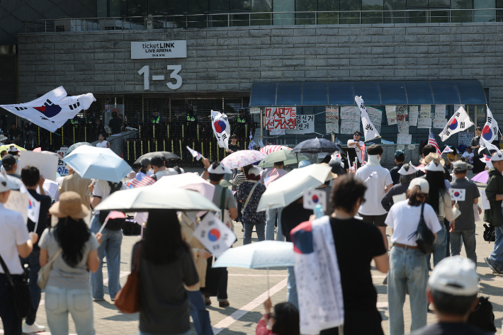 6·3 지방선거 투표용지 부족 사태를 규탄하는 '개표소 봉쇄 시위'가 이어진 12일 서울 송파구 올림픽공원 핸드볼경기장 앞에서 참가자들이 구호를 외치고 있다. 연합뉴스