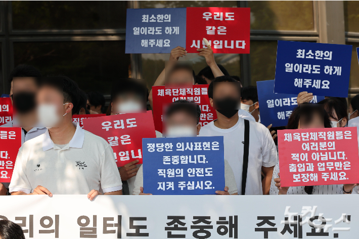 경기장에 사무실이 있는 체육단체 직원들이 "일터에 돌아가고 싶다"는 내용의 피켓을 들고 있다. 박종민기자