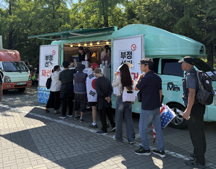 13일 오전 서울 올림픽공원 핸드볼경기장 앞에 설치된 커피차에서 시위 참가자들이 음료를 받고 있다. 김태헌 기자