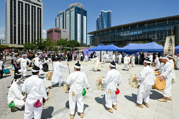 12일 부산역 광장에서 열린 밀양백중놀이보존회의 공연 현장에 많은 국내외 관광객들이 발길을 멈추고 관람하고 있다. 밀양시 제공