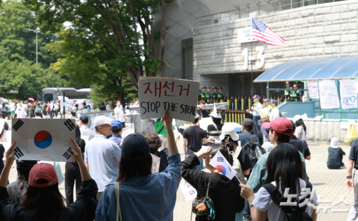 서울 송파구 올림픽공원 핸드볼경기장 출입구 앞에서 시위 참가자들이 구호를 외치고 있다. 류영주 기자