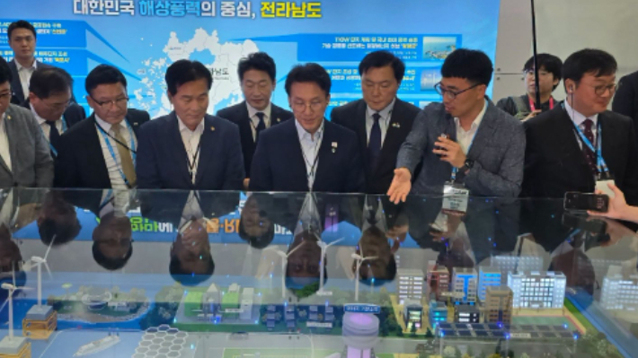 김민석(가운데) 국무총리가 '해상풍력 공급망 컨퍼런스' 전시관에서 해상풍력 관련 조감도 모형을 보며 설명을 듣고 있다. 주철현 의원실 제공