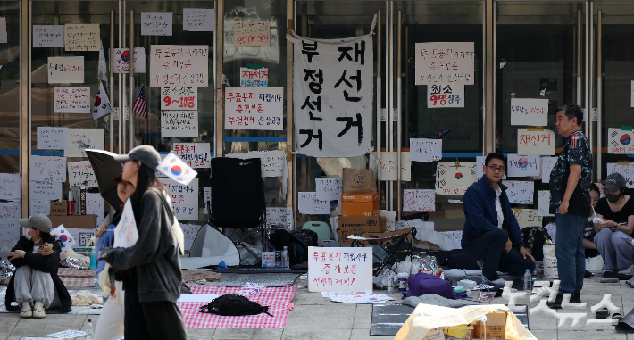 제9회 전국동시지방선거 투표용지 부족 사태에 대한 개표소 봉쇄 시위가 일주일째 이어지고 있는 11일 개표소로 이용됐던 서울 송파구 올림픽공원 핸드볼경기장 앞에서 시위대가 봉쇄 취지의 시위를 이어가고 있다. 박종민 기자