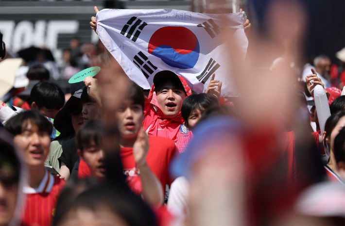 2026 북중미 월드컵 조별리그 A조 한국과 체코의 경기가 열렸던 12일 서울 종로구 광화문광장에 설치된 축구 거리응원 무대에서 한 시민이 태극기를 들고 있다. 연합뉴스