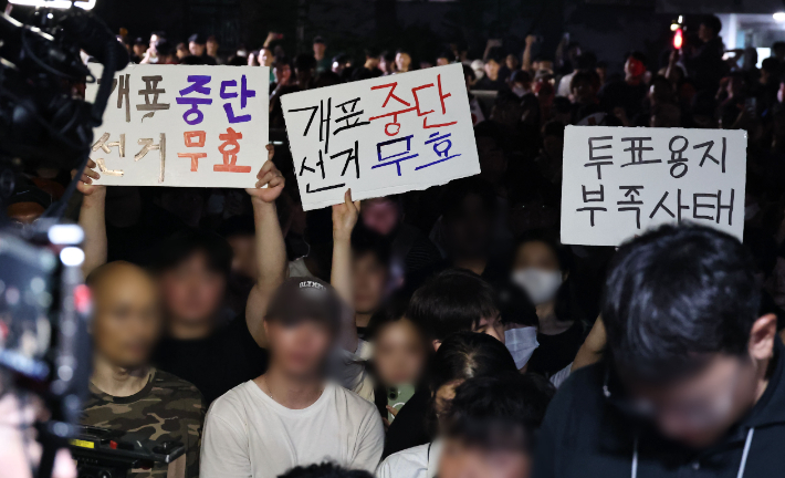 4일 제9회 전국동시지방선거 및 국회의원 재·보궐선거 투표용지 부족으로 투표 시간이 오후 10시까지 연장됐던 서울 송파구 잠실7동 제2투표소 앞에서 '부정선거' 등 손팻말을 든 시민들이 구호를 외치고 있다. 연합뉴스