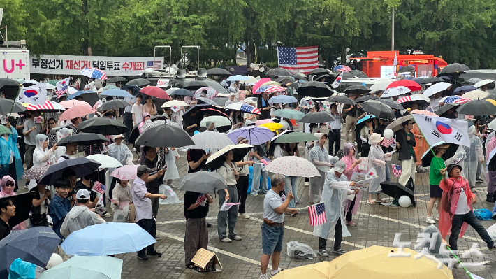19일 서울 송파구 올림픽공원 핸드볼경기장에서 우산을 쓰고 집회에 참가하고 있는 모습. 조은샘 수습기자