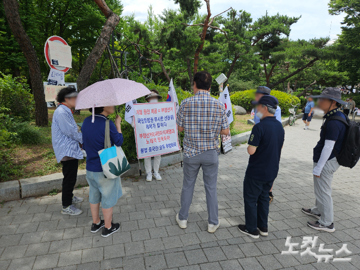 21일 오후 서울 올림픽공원 핸드볼경기장 인근에서 고령층 시위 참가자들이 부정선거에 대해 대화를 나누고 있다. 이원석 기자