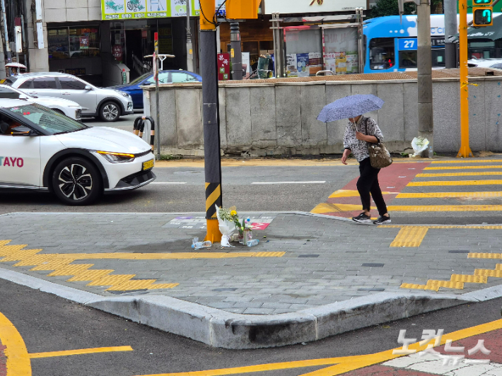 지난 21일 오후 1시 10분쯤 부산 남구 대연동의 한 삼거리에서 70대 운전자가 몰던 차량이 인도를 덮쳐 보행자 2명이 숨졌다. 사고가 발생한 현장에 피해자들을 추모하는 꽃다발이 놓여있다. 정혜린 기자