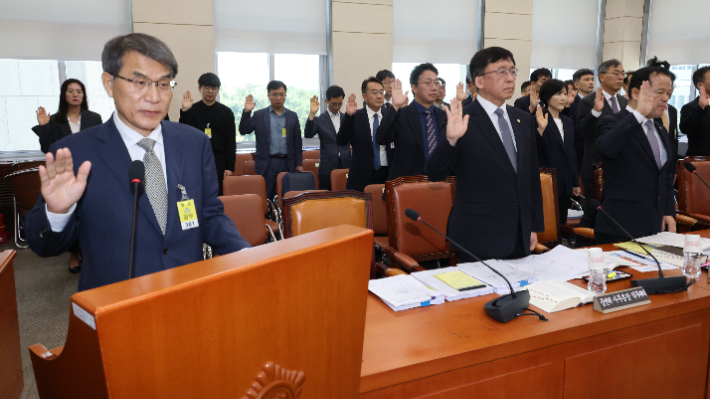 노태악 전 중앙선거관리위원장이 23일 국회에서 열린 투표용지 부족사태 등 국민참정권 침해 진상규명 및 선거관리 개혁을 위한 국정조사 특위 전체회의에서 위철환 선관위원장 직무대행, 허철훈 전 사무총장 등과 기관 보고에 앞서 선서하고 있다. 연합뉴스