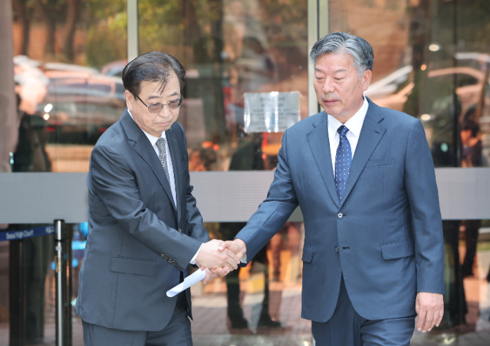 서훈 전 청와대 국가안보실장(왼쪽)과 김홍희 전 해양경찰청장이 지난 16일 서울 서초구 서울고법에서 열린 서해 공무원 피격 사건 관련 2심 선고 공판을 마친 후 법정을 나서며 악수하고 있다. 연합뉴스