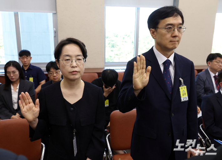 민소영 전 송파구선거관리위원장(왼쪽)과 오민석 전 서울시선거관리위원장이 23일 국회에서 열린 '제9회 전국동시지방선거 투표용지 부족사태 등 국민참정권 침해 진상규명 및 선거관리 개혁을 위한 국정조사 특별위원회' 에 출석해 증인선서를 하고 있다. 황진환 기자