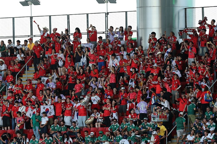 2026 북중미 월드컵 A조 2차전 한국과 멕시코의 경기. 한국 축구 팬들이 모여 앉아 응원하고 있다.