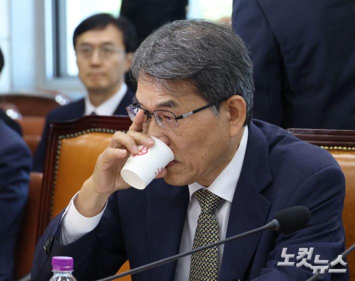 노태악 전 중앙선거관리위원회 위원장이 23일 국회에서 열린 '제9회 전국동시지방선거 투표용지 부족사태 등 국민참정권 침해 진상규명 및 선거관리 개혁을 위한 국정조사 특별위원회' 회의에 출석해 물을 마시고 있다. 뒤쪽은 오민석 전 서울시선거관리위원장. 황진환 기자