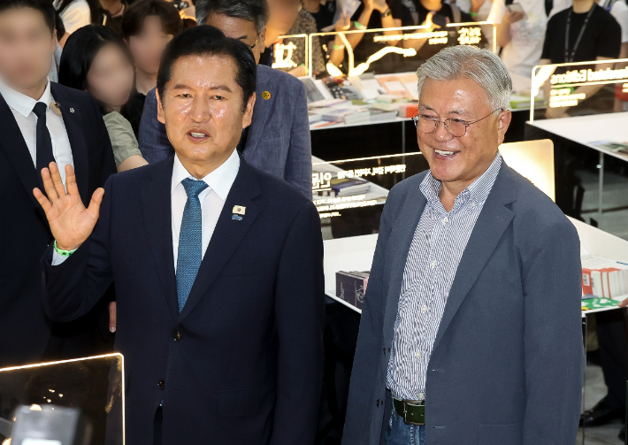 문재인 전 대통령과 정청래 전 더불어민주당 대표가 24일 서울 강남구 코엑스에서 열린 서울국제도서전에서 시민들에게 인사하고 있다. 연합뉴스