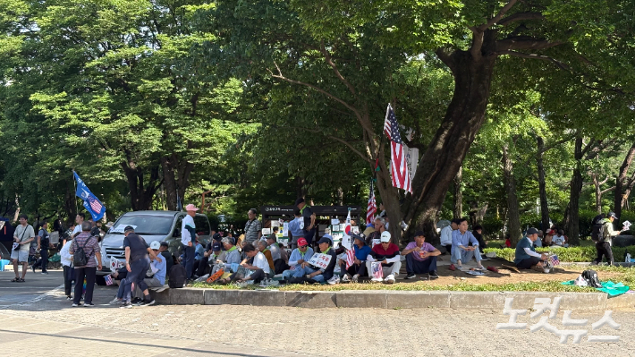 24일 오후 서울 송파구 올림픽공원 핸드볼경기장 앞 '개표소 봉쇄 시위' 현장에서 시위 참가자들이 그늘을 찾아 휴식을 취하고 있다. 김하영 수습기자