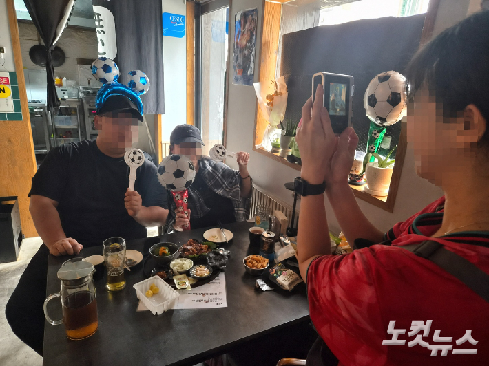 2026 FIFA 북중미 월드컵 A조 예선 대한민국과 남아프리카공화국과의 경기가 있었던 25일 오전 광주 광산구의 한 요리주점을 찾은 손님들이 기념사진을 촬영하고 있다. 정유철 기자
