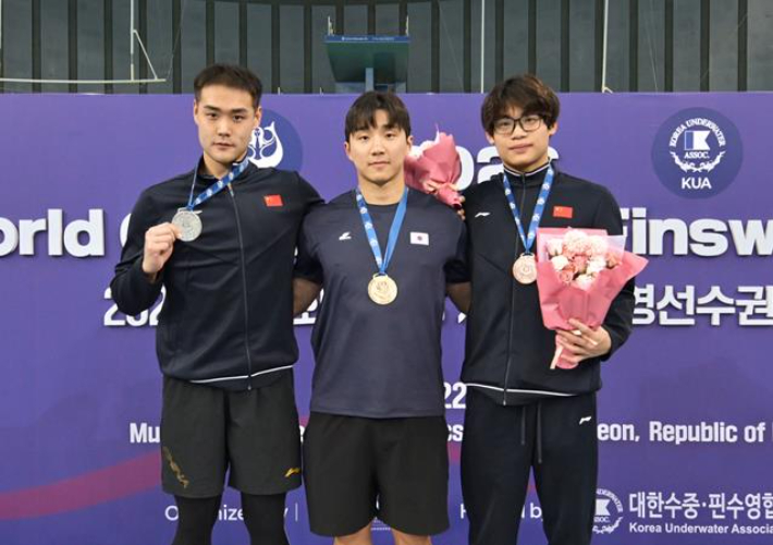 핀수영 간판 신명준(사진 가운데)이 25일 인천 문학박태환수영장에서 열린 제24회 세계수중연맹(CMAS) 세계핀수영선수권대회 남자 호흡잠영 100ｍ에서 30초70의 세계 기록으로 우승한 뒤 금메달을 목에 걸고 포즈를 취하고 있다. [대한수중핀수영협회 제공.