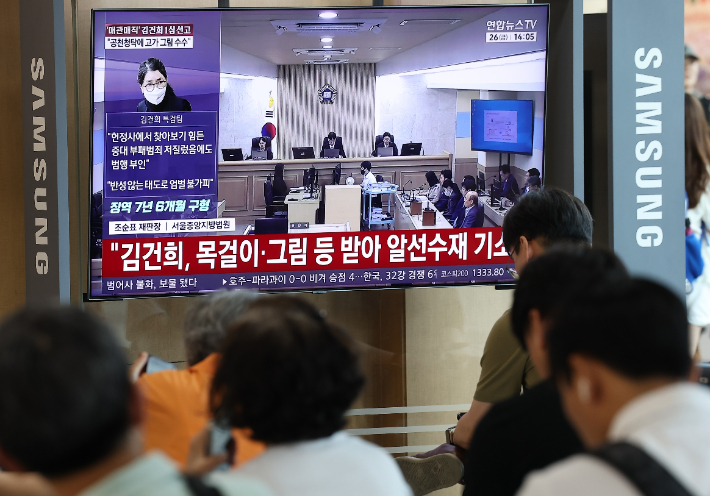  고가 귀금속과 함께 인사·이권 청탁을 받은 이른바 '매관매직' 혐의로 기소된 김건희 여사의 1심 선고가 열린 26일 서울역에서 시민들이 관련 방송을 지켜보고 있다. 연합뉴스
