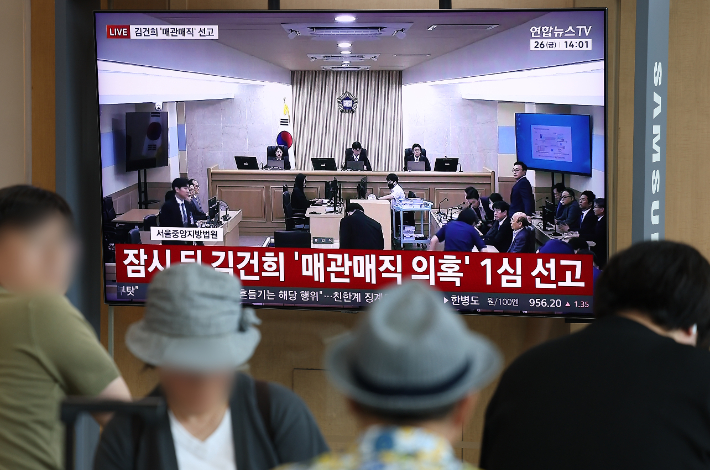 각종 고가 귀금속과 함께 인사·이권 청탁을 받은 이른바 '매관매직' 혐의로 기소된 김건희 여사의 1심 선고가 열린 26일 서울역에서 시민들이 관련 방송을 지켜보고 있다. 연합뉴스