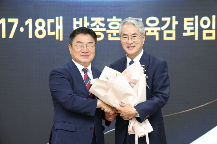 박종훈 경남교육감이 26일 퇴임식에서 권순기 경남교육감 당선인으로부터 꽃다발을 받고 있다. 경남교육청 제공
