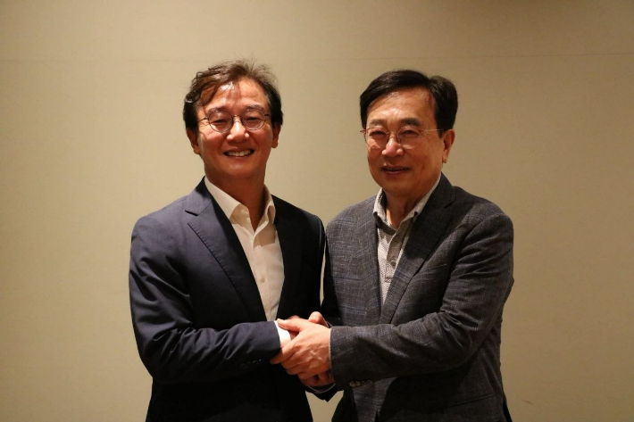 전재수 부산시장 당선인(왼쪽)이 서병수 전 시장(오른쪽)을 만나 악수하고 있다. 전재수 당선인 측 제공 