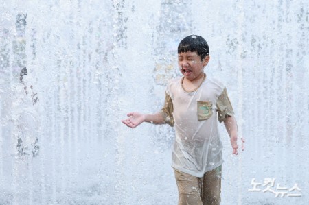 30도 안팎의 땡볕 더위가 이어지고 있는 28일 서울 종로구 광화문 광장 분수대를 찾은 어린이가 더위를 식히고 있다.