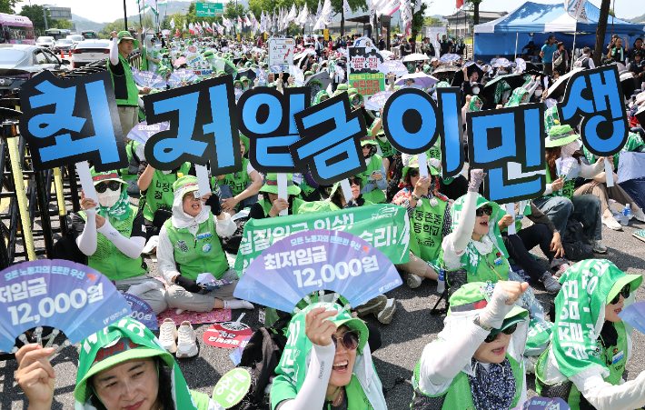 27일 서울 종로구 열린송현녹지광장 앞에서 열린 민주노총 최저임금 인상 결의대회에서 참석자들이 구호를 외치고 있다. 연합뉴스