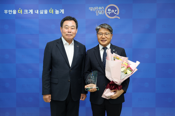 전남개발공사 장충모 사장이 29일 무안군청서 남악신도시 조성 공로로 무안군 김산군수로부터 감사패를 받은 후 기념사진을 찍고 있다. 전라남도 제공