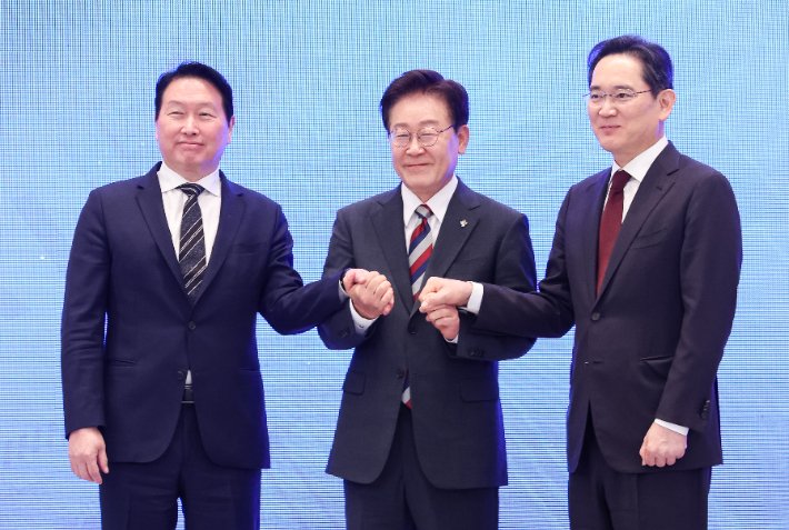 이재명 대통령과 이재용 삼성전자 회장, 최태원 SK그룹 회장이 29일 청와대에서 열린 3대 메가프로젝트 국민보고회에서 기업 투자 발표 후 손을 잡고 있다. 연합뉴스