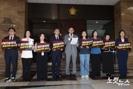 조국혁신당 김준형 원내대표가 30일 서울 여의도 국회 로텐더홀에서 열린 의원총회에서 피켓을 들고 발언하고 있다.