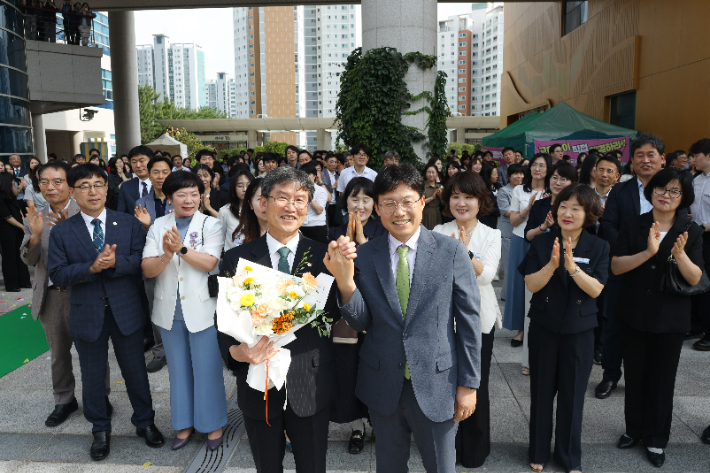 조용식 울산교육감 당선인이 6월 30일 천창수 울산교육감에게 꽃다발을 전달하고 기념촬영을 하고 있다. 울산교육청 제공