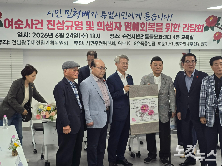 민형배 당선인이 유족들과 함께 호소문이 담긴 족자를 들고 기념촬영했다. 고영호 기자