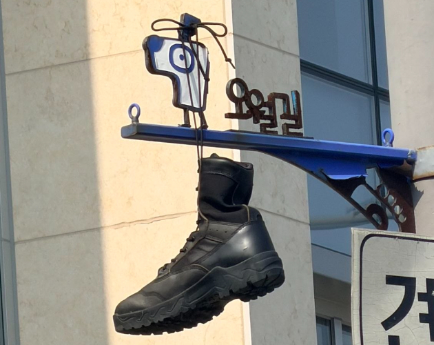 30일 오전 광주 동구 옛 시외버스터미널 부지 오월길 안내판에 군화가 걸려 있다. 독자 제공